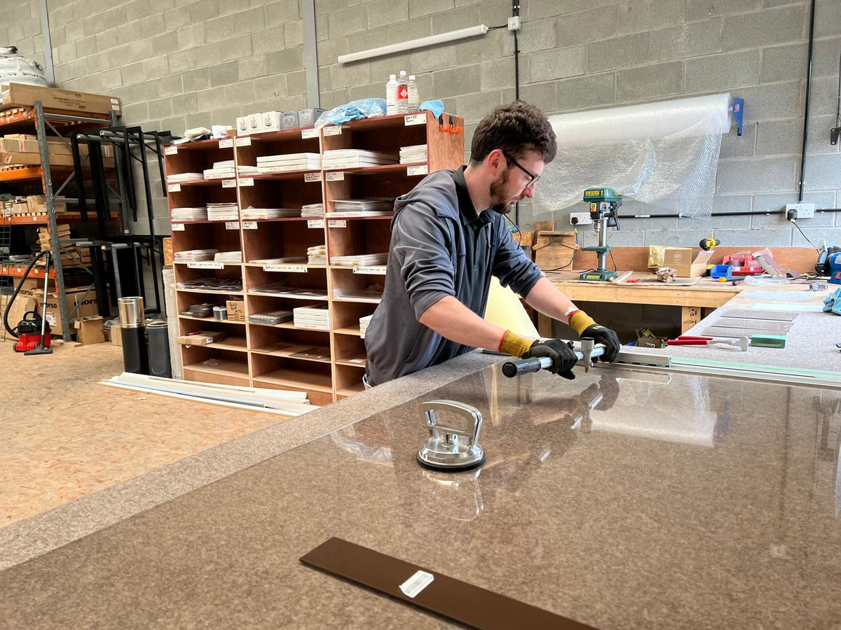 A team member cutting stove glass at the Newtownards workshop